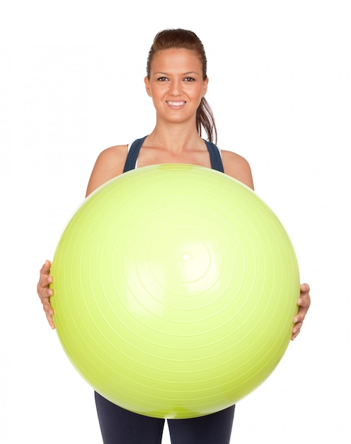 Attractive girl practicing pilates with a big green ball