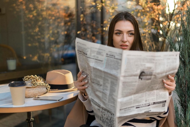 Привлекательная девушка читает газету в парке Частный детектив наблюдения следит за объектомПривлекательный агент разведки