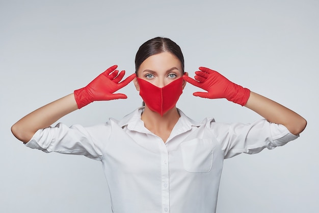 Attractive girl in red gloves and a face mask.