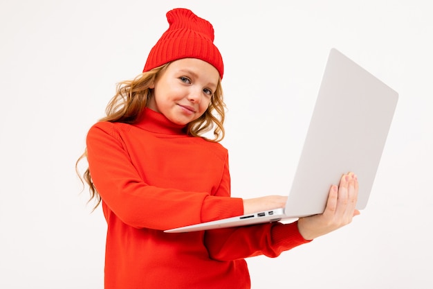 Attractive girl in a red hat writes a message on a notebook