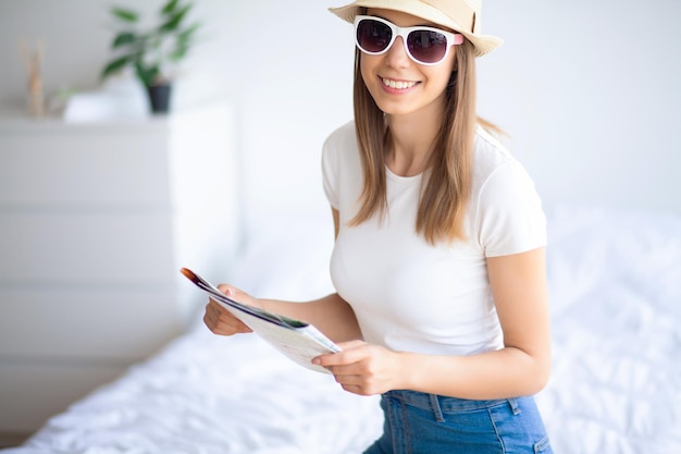 Attractive girl sitting on sofa and packing luggage