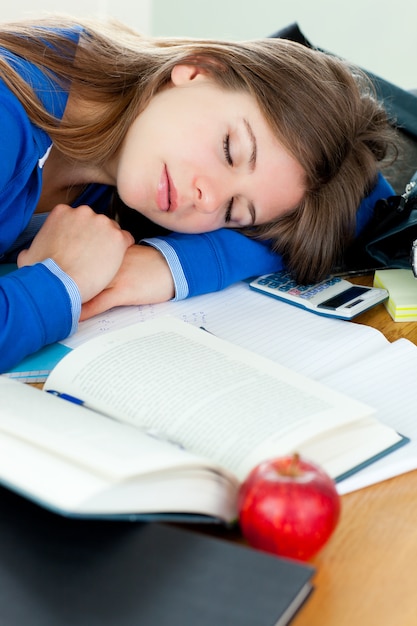 Foto ragazza attraente che dorme alla sua scrivania