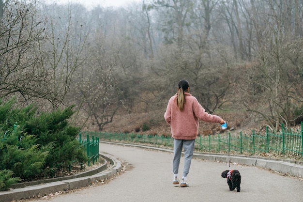 Attractive girl spending time with a pet on the street