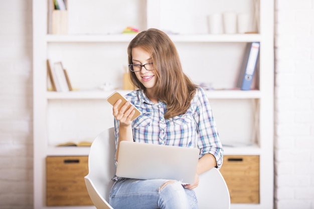 Attractive girl using laptop and smartphone