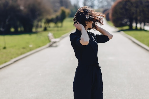 Attractive girl walking on park road in sunny day