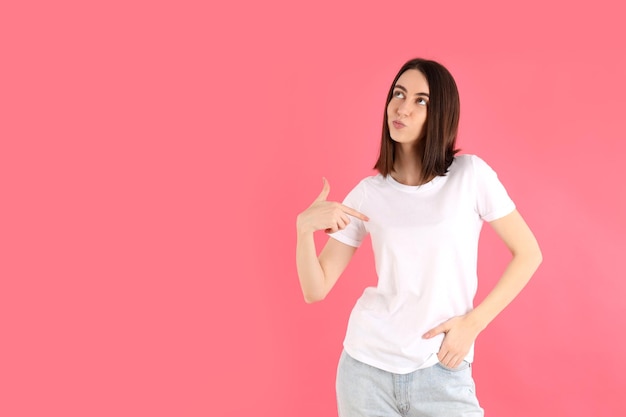 Attractive girl in white t-shirt on pink background