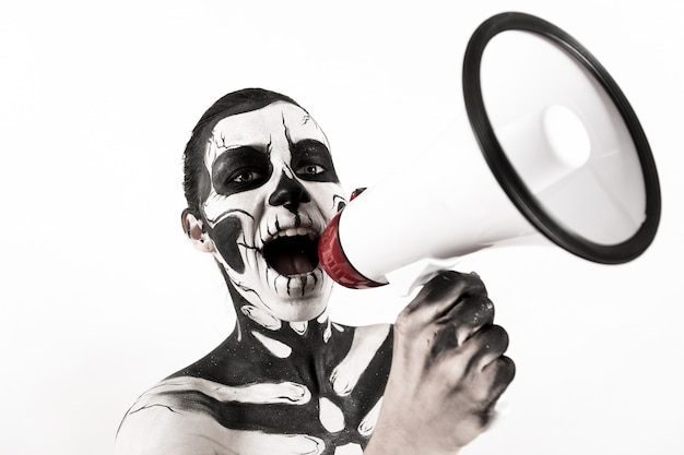 Attractive girl with skeleton makeup hold megaphone