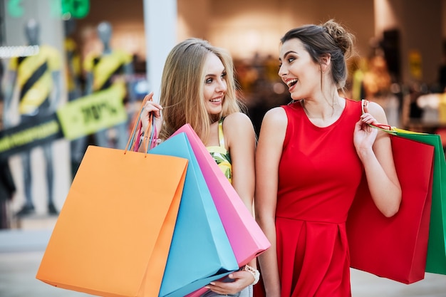 Ragazze attraenti nel centro commerciale con i sacchetti