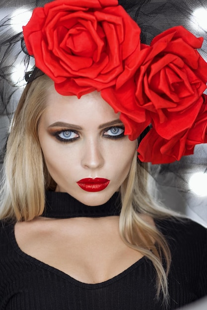 Attractive Goth female with bright makeup wearing amazing rose headgear and looking at camera