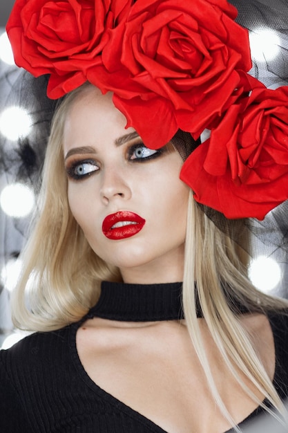 Attractive Goth female with bright makeup wearing amazing rose headgear and looking at camera
