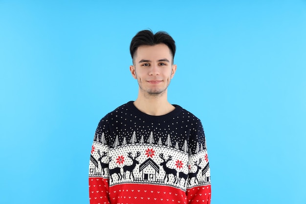 Attractive guy in Christmas sweater on blue background