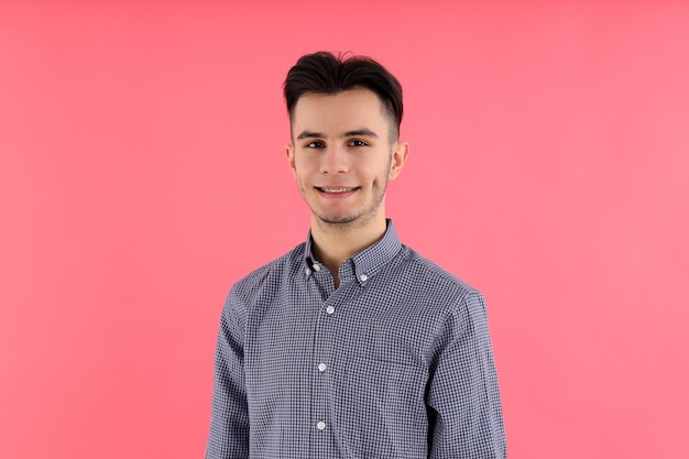 Attractive guy in shirt on pink background