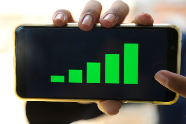 attractive hands showing profit graph on a smart phone