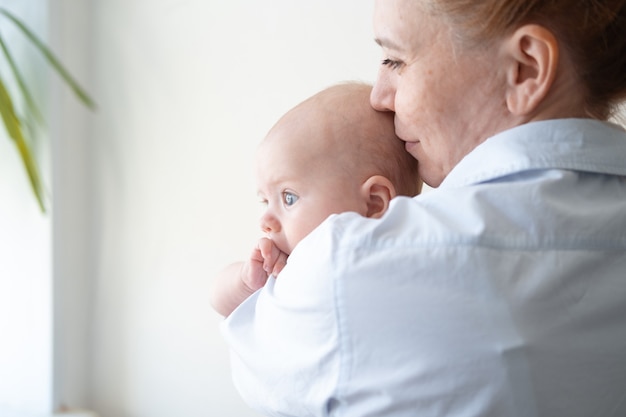 Attractive happy mother hold kiss little baby boy. Happy family. Childcare and maternity concept. enjoy a moment At home. Love. Sweet. Tenderness. High quality photo