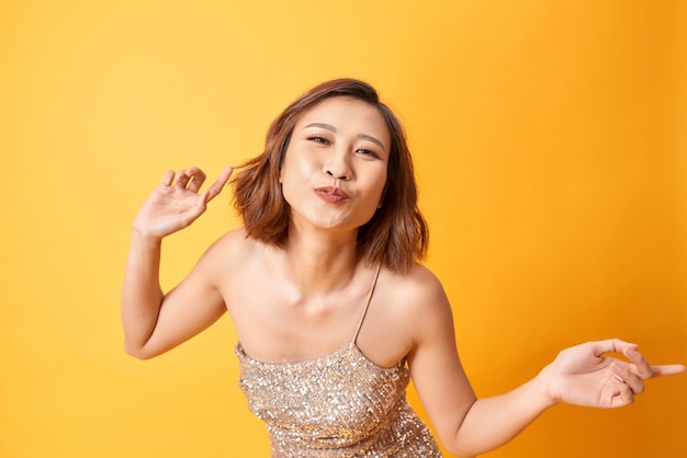 Attractive happy smiling woman in glitter dress with dancing celebrating Christmas and new year