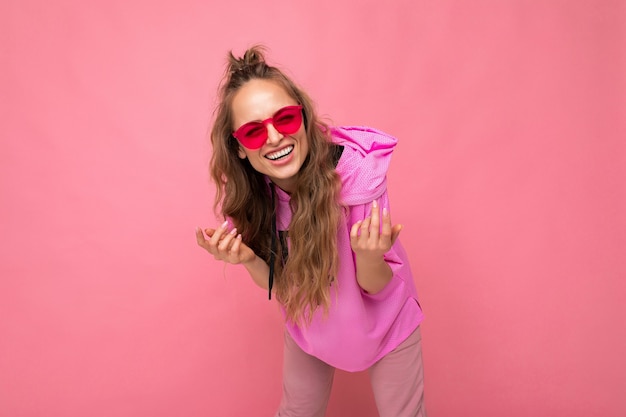 Attractive happy smiling young blonde woman wearing everyday stylish clothes and modern sunglasses