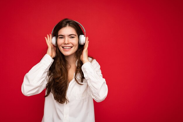 Attractive happy smiling young brunette female person wearing white shirt and optical glasses