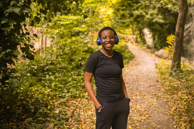 Attractive happy smiling young natural beauty short haired african black woman with blue headphones