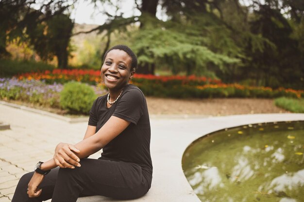 Foto attraente sorridenti giovane bellezza naturale dai capelli corti donna africana che indossa total black