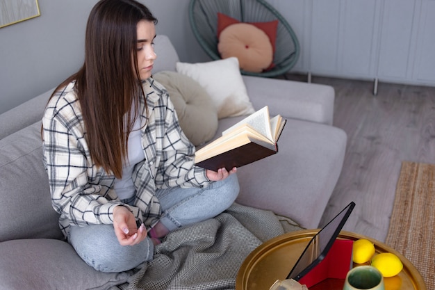 Attractive happy young college girl reading book