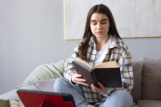 Attractive happy young college girl reading book