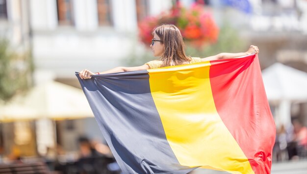ベルギーの旗を持つ魅力的な幸せな少女