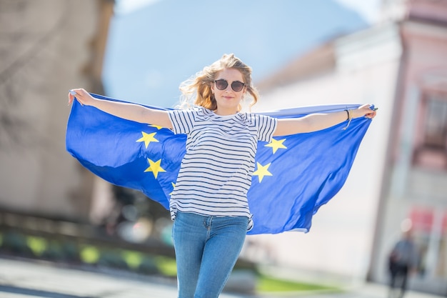 Attractive happy young girl with the flag of the European Union.