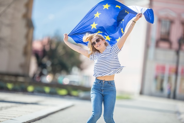 Attractive happy young girl with the flag of the European Union.