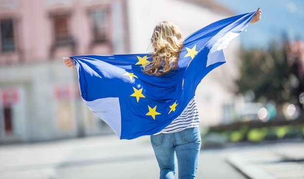 Attractive happy young girl with the flag of the European Union.