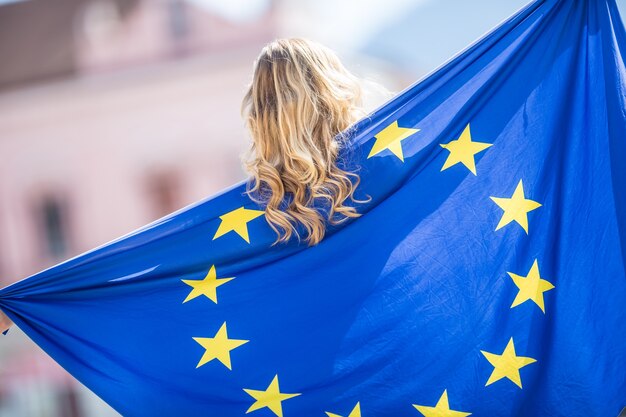 Attractive happy young girl with the flag of the European Union.