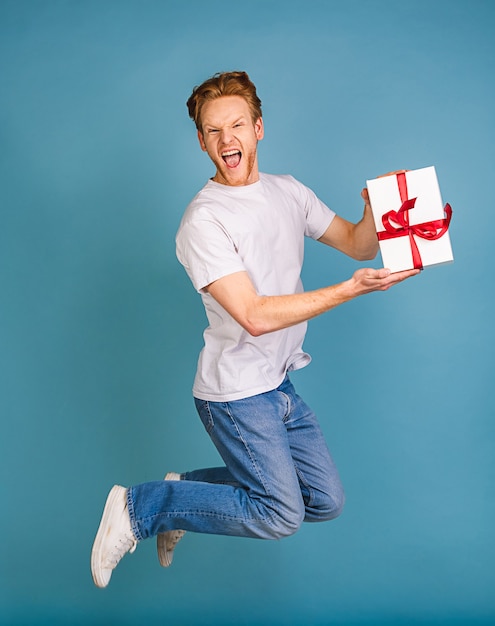 attractive happy young man with beautiful smile holding his birthday present box