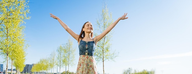 Attractive happy young woman long flowered dress flying her hair enjoying free