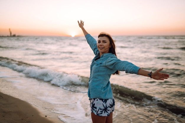 Attractive happy young woman in white t shirt flying hair enjoying her free time at sunset outdoor