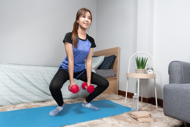 Attractive and healthy young Asian woman doing exercising at home