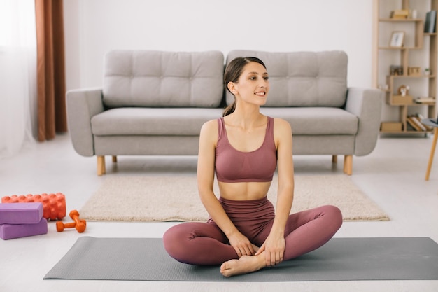 Attractive and healthy young woman doing exercises while resting at home