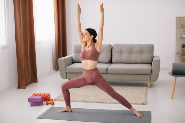 Attractive and healthy young woman doing exercises while resting at home