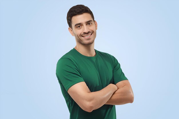 Attractive joyful handsome sporty man in green tshirt standing with crossed arms