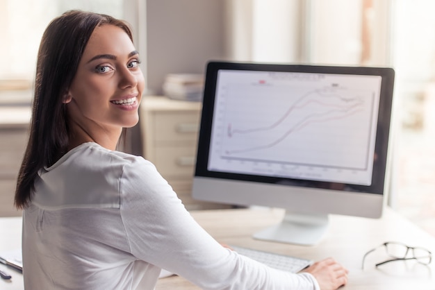 Attractive lady in stylish clothes is using a computer.