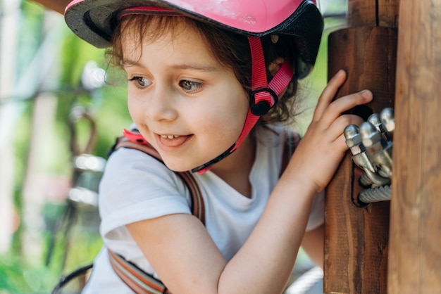 写真 ケーブルカーの保護ヘルメットをかぶった魅力的な少女。女の子は積極的に屋外で時間を過ごしています