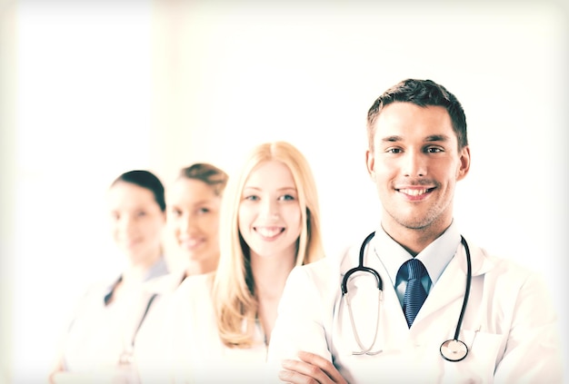 attractive male doctor in front of medical group