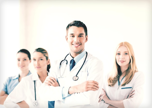 attractive male doctor in front of medical group