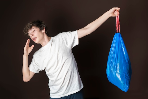 Attractive male hold smelly garbage bag isolated. take out trash concept s