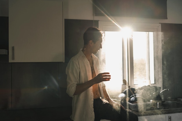 Attractive male slob drinking whiskey in his kitchen