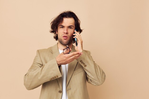 Comunicazione uomo attraente per telefono vestito beige stile elegante stile di vita inalterato