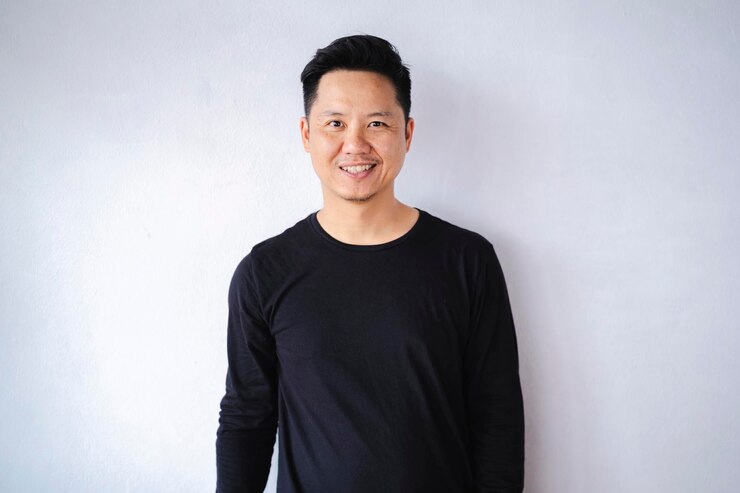 Photo an attractive man in his 40s standing against a white background wearing a blue hood shirt smiling