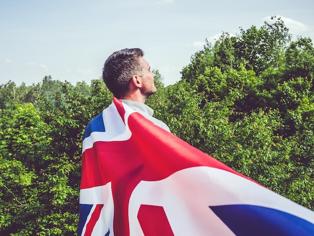 Attractive man holding British Flag, close up