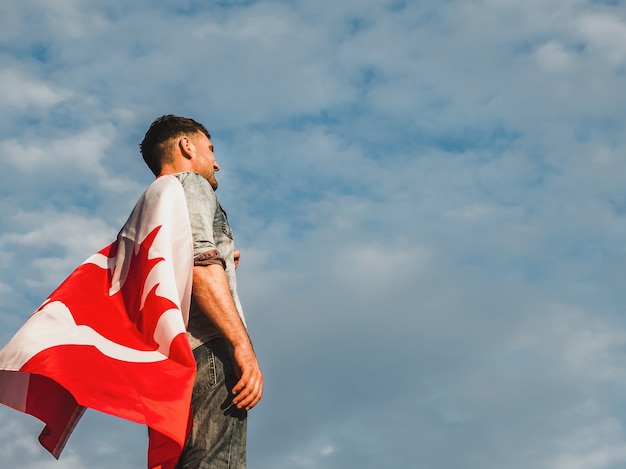 Photo attractive man holding canadian flag. national holiday