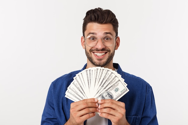 Attractive man is holding cash money in one hand, on isolated white