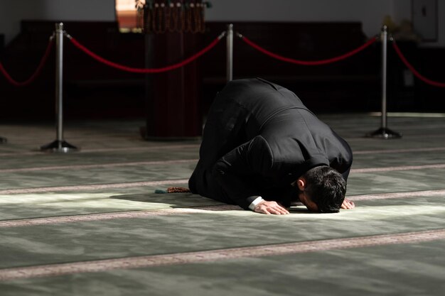 Photo attractive man making traditional prayer to god allah in the mosque