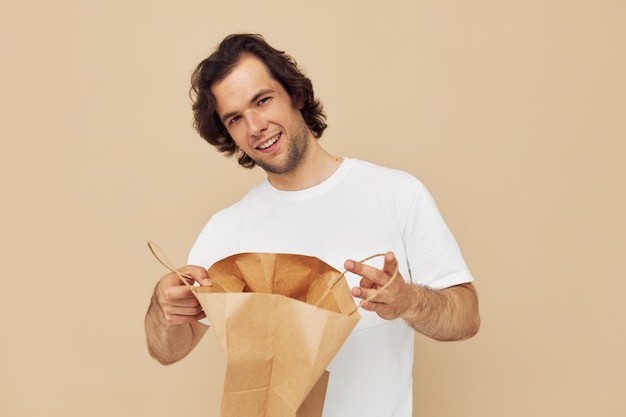 Attractive man paper bag emotions posing isolated background